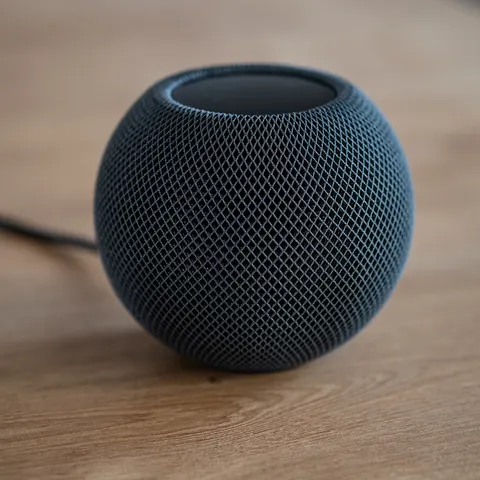Parlante inteligente con asistente de voz sobre una mesa de madera